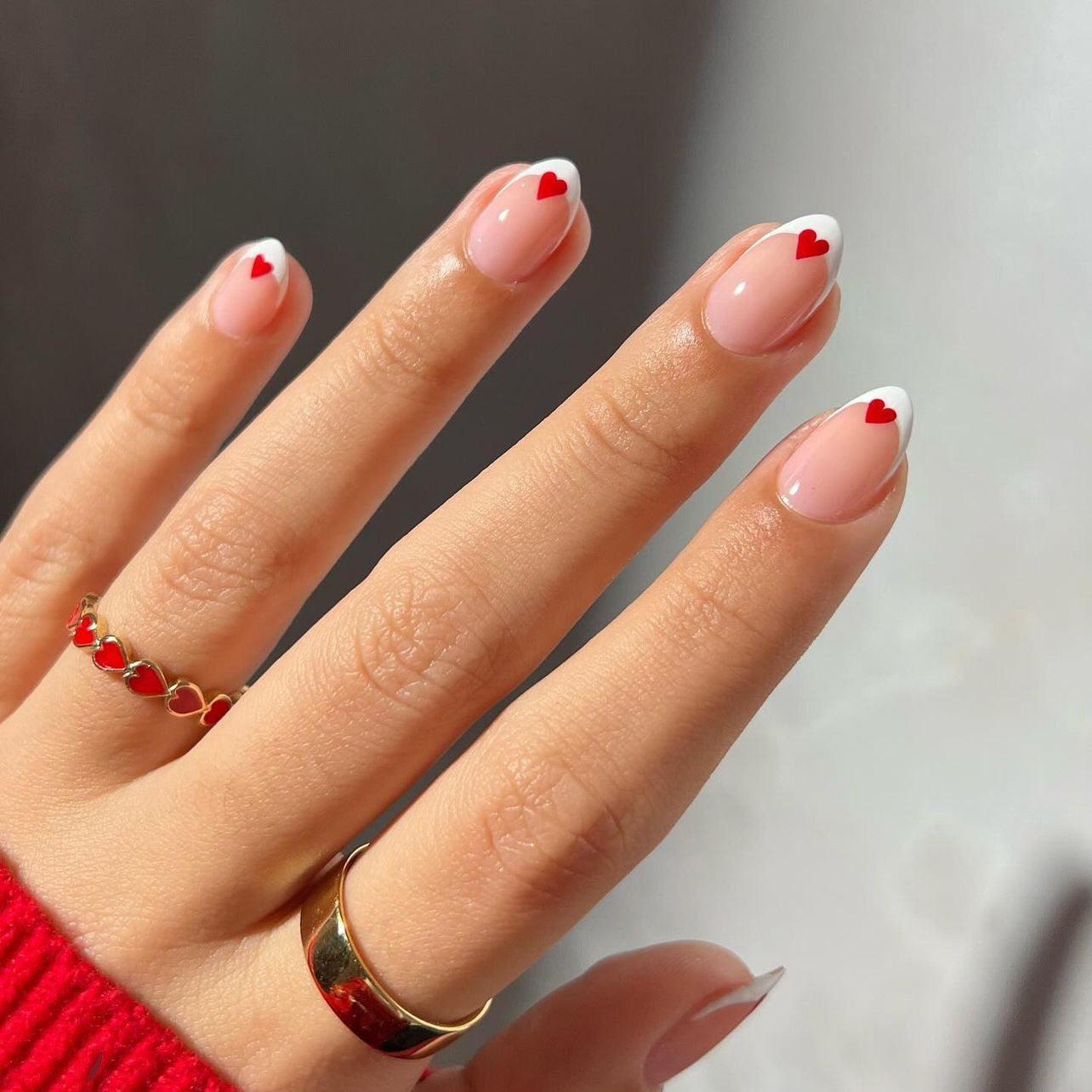 Amour French press-on nails with red heart accents and classic French tips.