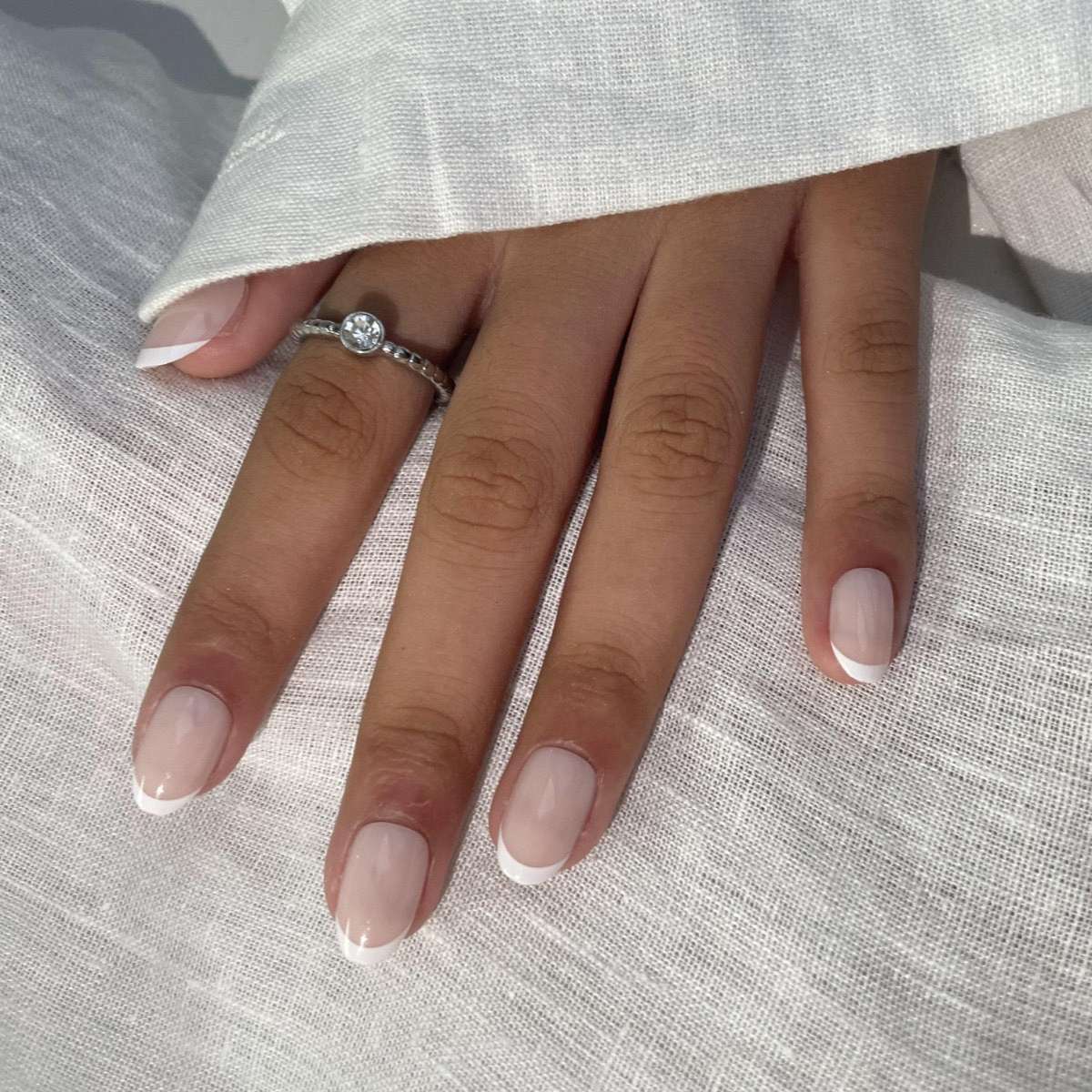 Light French Round press-on nails with subtle white tips and a natural rounded shape