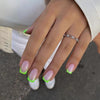Hand with neon lime French tip press-on nails, square shape, photographed outdoors in natural light