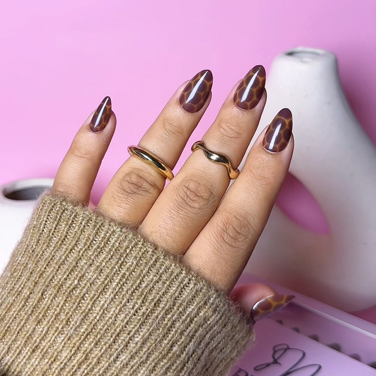 Close-up of Impress Me Toffee Hive giraffe-style press-on nails in Beirut – trendy brown patterned nails for fall